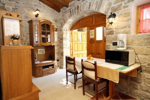 a kitchen with a table with a microwave and chairs at Apartments with WiFi Groznjan, Central Istria - Sredisnja Istra - 7038 in Grožnjan