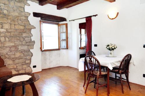 a dining room with a table and a stone wall at Apartment Groznjan 7038a in Grožnjan