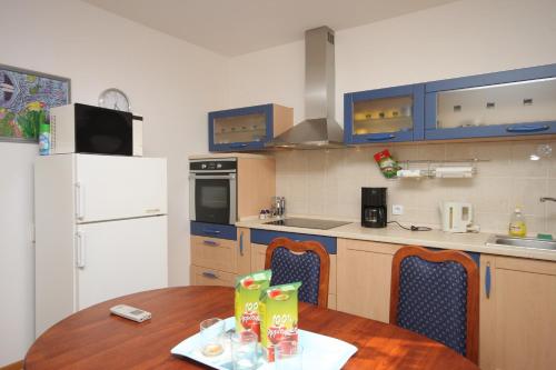 een keuken met een houten tafel en een witte koelkast bij Apartment Barici 7003a in Umag