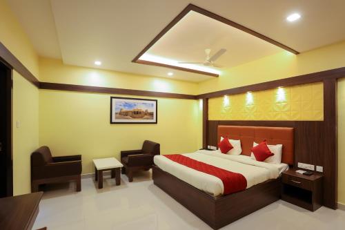 a bedroom with a bed and a desk and a chair at sri balaji grand hotel in Kumbakonam