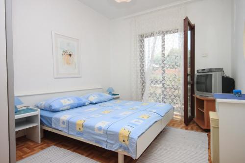 a bedroom with a bed and a tv and a window at Apartments with a parking space Porec - 7024 in Poreč