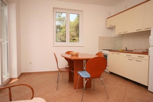 a kitchen with a wooden table and chairs at Apartments with a parking space Novigrad - 7017 in Novigrad Istria