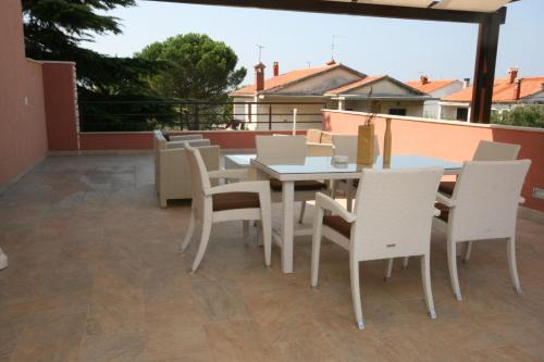 een patio met een tafel en stoelen op een balkon bij Apartments by the sea Umag - 7029 in Umag