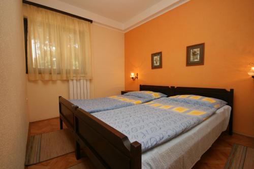 sypialnia z dużym łóżkiem i pomarańczowymi ścianami w obiekcie Apartments by the sea Umag - 7029 w mieście Umag