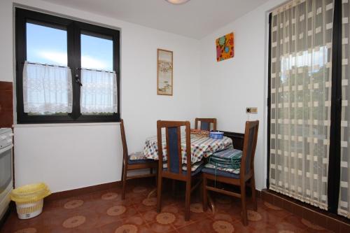 a dining room with a table and chairs and a window at Apartments with a parking space Zambratija, Umag - 7059 in Zambratija