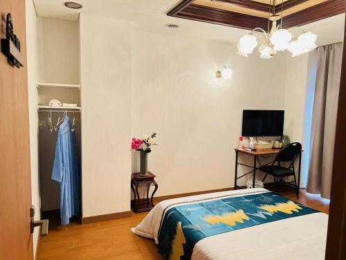 a bedroom with a bed and a desk and a television at 福宿 Fukuinn 101号室 in Takamatsu