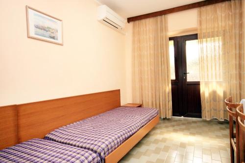 a bedroom with a bed and a window and a door at Holiday house with a parking space Tar, Porec - 7025 in Tar