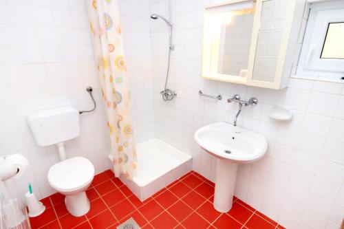 a white bathroom with a toilet and a sink at Holiday house with a parking space Tar, Porec - 7025 in Tar
