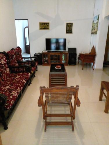 a living room with a couch and a tv at Muthu Villa in Kalutara