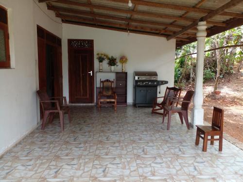 una casa con patio con sillas y fogones. en Muthu Villa, en Kalutara