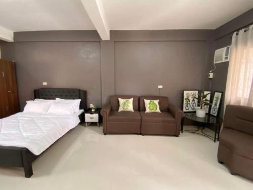 1 dormitorio con 1 cama y 1 sofá en Adam's Hotel Apartment en Pandi