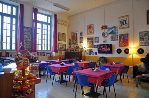 a restaurant with red tables and blue chairs at Litus Roma Hostel in Lido di Ostia