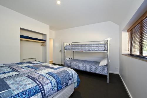 Un dormitorio con dos camas y una ventana. en Margaret River Bungalow-1-street - pet friendly, en Margaret River Town