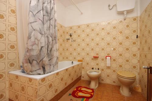 een badkamer met een toilet en een douchegordijn bij Apartments with a parking space Umag - 6994 in Umag