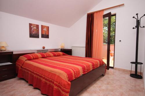 sypialnia z dużym łóżkiem i czerwonym kocem w obiekcie Apartments by the sea Zambratija, Umag - 6997 w mieście Zambratija