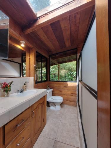 a bathroom with a toilet and a sink at The Temple II, Mindo in Mindo