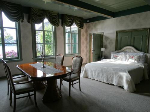 a bedroom with a bed and a table and chairs at Heerlijck Slaapen op de Zaanse Schans in Zaandam