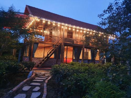 a house with lights on the side of it at Tea Garden House in Xã Tân Phát