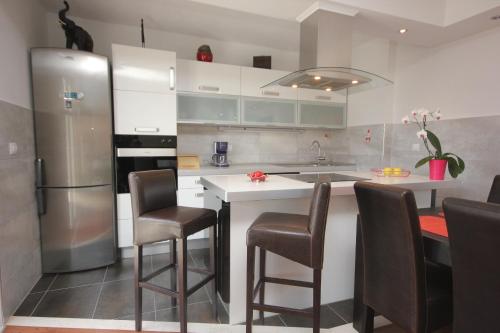a kitchen with a refrigerator and a counter with chairs at Apartments with WiFi Cavtat, Dubrovnik - 9063 in Cavtat