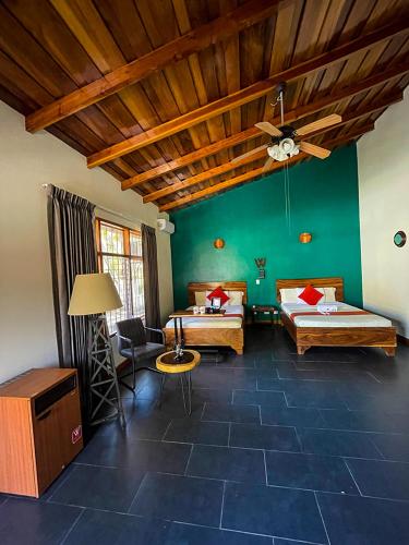 a room with two beds and a ceiling fan at Hotel El Regalo in Nicoya