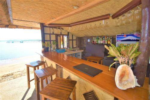 un bar en la parte trasera de una casa de playa en Concepcion Divers Lodge en Busuanga
