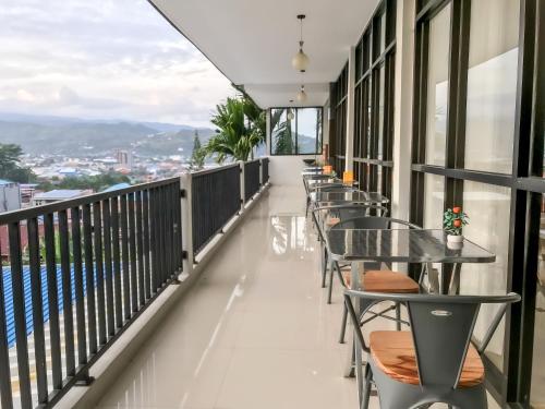 een balkon van een hotel met tafels en stoelen bij RedDoorz @ Gerson Hotel Abepura in Tobadi