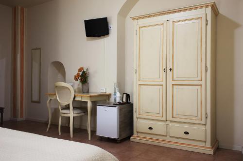 a bedroom with a bed and a desk and a cupboard at Camere Centro Storico in Canelli