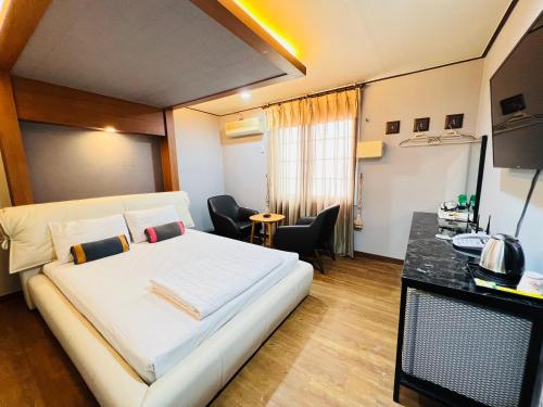 Un dormitorio con una gran cama blanca y una mesa en Sweet Hotel, en Jeju