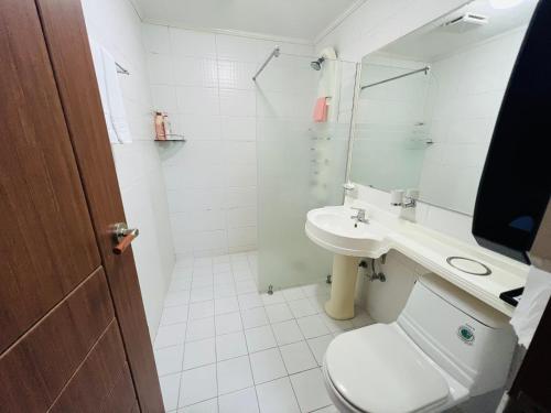 a bathroom with a toilet and a sink and a shower at Sweet Hotel in Jeju