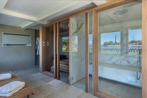 um quarto com portas de vidro e vista para a água em Ca' delle Contesse - Villa on lagoon with private dock and spectacular view em Veneza-Lido