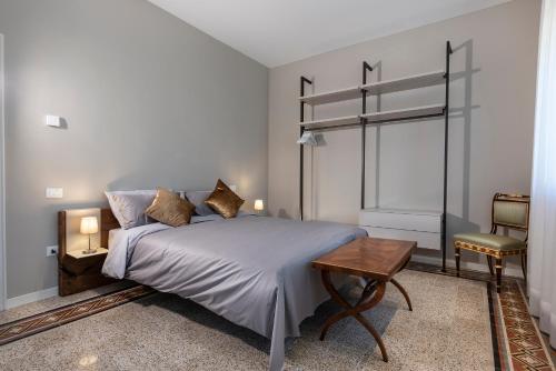 a bedroom with a bed and a table and a window at Ca' delle Contesse - Villa on lagoon with private dock and spectacular view in Venice-Lido