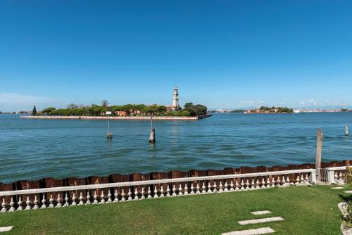 a view of the water with a lighthouse in the distance at Ca' delle Contesse - Villa on lagoon with private dock and spectacular view in Venice-Lido