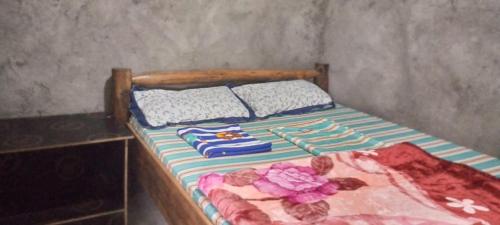 a bed with two pillows on it in a room at Sunrise homestay Sipi in Kapchorwa