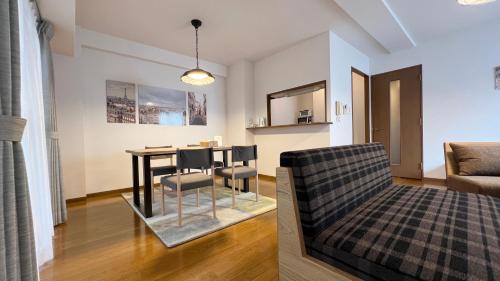 a dining room and living room with a table and chairs at Dio Higashi Shinsaibashi in Osaka