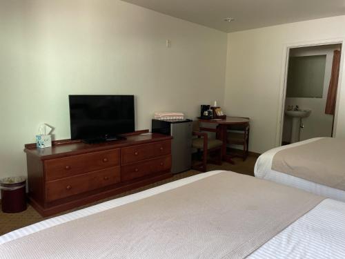 ein Schlafzimmer mit einem Bett und einem TV auf einer Kommode in der Unterkunft Carson Hot Springs Resort & Spa in Carson