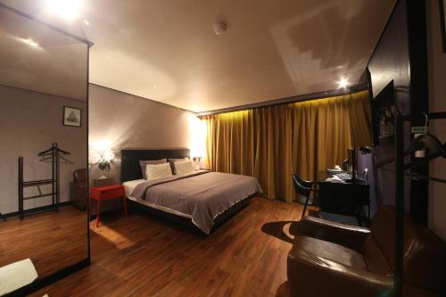 釜山にあるHotel Frenchcodeのベッドとデスクが備わるホテルルームです。