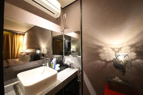 a bathroom with a sink and a mirror at Hotel Frenchcode in Busan