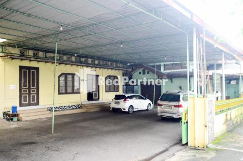 a parking lot with two cars parked in front of a building at PKPN Syariah Boyolali Mitra RedDoorz in Mojosongo