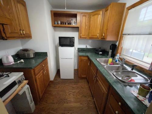 a kitchen with a white refrigerator and a sink at HOKUTO SATOYAMA BASE in Hokuto