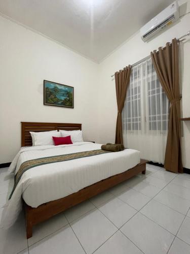 a bedroom with a large bed and a window at AW City House Yogyakarta in Yogyakarta