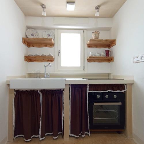 a kitchen with a sink and a stove at Lisa Dimora Salentina in Andrano