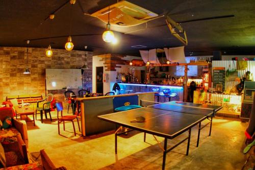 a room with a table and chairs and a bar at 秘密基地 NO's ARROW ノーズアロー in Onna