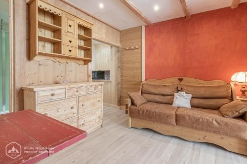 a living room with a couch and a red wall at LA CAZETTA in Bonneval-sur-Arc