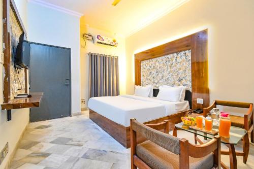 a bedroom with a bed and a table and a television at FabHotel Classic Holiday in Jaipur