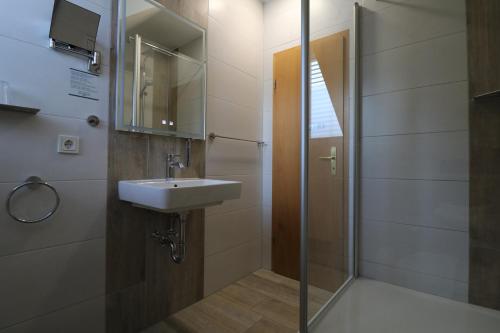 a bathroom with a sink and a shower at Pension & Restaurant Nordstern in Cottbus
