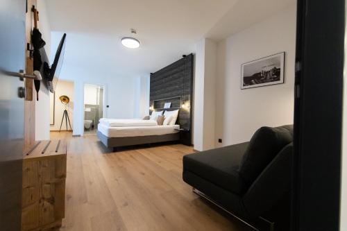 sala de estar con sofá y cama en Self-Check-in Hotel VinoQ Zistersdorf, en Zistersdorf