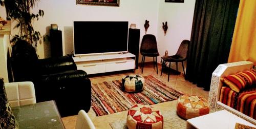 a living room with a flat screen tv and a couch at Charmante maison au calme in Sainte-Maure