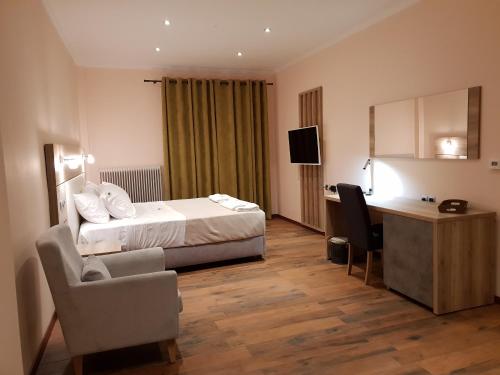 a hotel room with a bed and a desk at Mondeus Inn Luxury in Deskáti