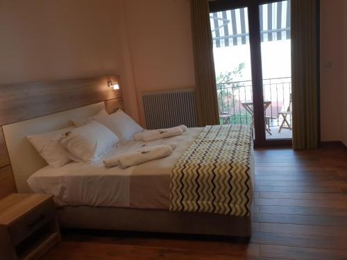 a bedroom with a large bed with a balcony at Mondeus Inn Luxury in Deskáti