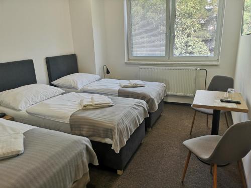 Zimmer mit 3 Betten, Tisch und Stühlen in der Unterkunft Penzion DON in Třebíč